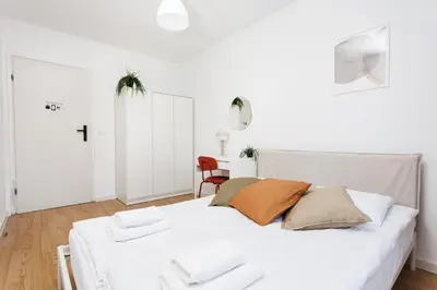 a white bedroom with a white bed and a table at Pretty 4 Bedroom Apartment in City Center - by Upstairs in Kraków