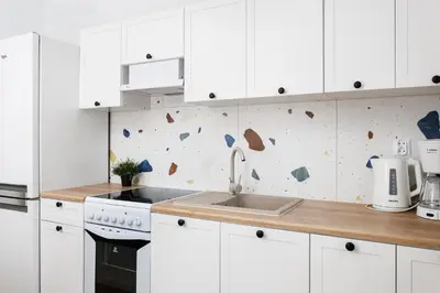 a kitchen with white cabinets and a sink at Pretty 4 Bedroom Apartment in City Center - by Upstairs in Kraków