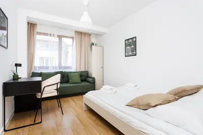 a bedroom with a bed and a desk and a couch at Pretty 4 Bedroom Apartment in City Center - by Upstairs in Kraków
