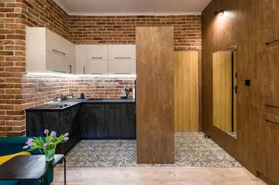a kitchen with a wooden door and a brick wall at Feel like home in Kraków in Kraków