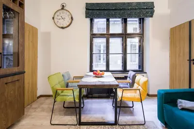 a dining room with a table and chairs and a clock at Feel like home in Kraków in Kraków