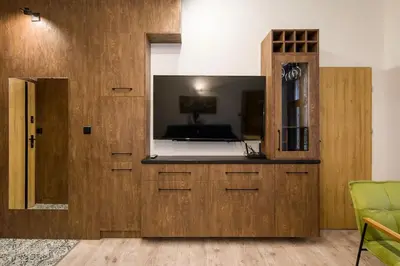 a room with a large wooden cabinet with a mirror at Feel like home in Kraków in Kraków