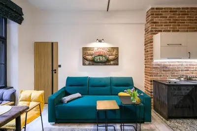 a living room with a blue couch and a brick wall at Feel like home in Kraków in Kraków