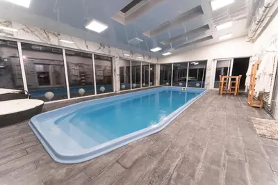 a large swimming pool in a room with a table and chairs at ŁOSOSINA 365 Dom z basenem in Łososina Dolna