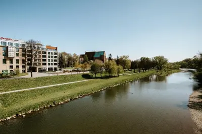 a river in a city with a building in the background at River Side Residence 3/19 in Oświęcim
