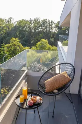 a balcony with a table with breakfast foods and orange juice at River Side Residence 3/19 in Oświęcim