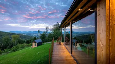 a house with a deck with a view of the mountains at Czas i Las Glamping in Sadek