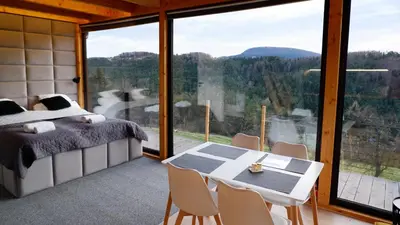 a bedroom with a bed and a table and chairs at Czas i Las Glamping in Sadek