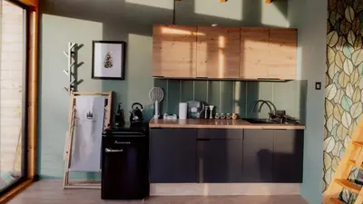 a kitchen with a refrigerator and a counter top at Czas i Las Glamping in Sadek