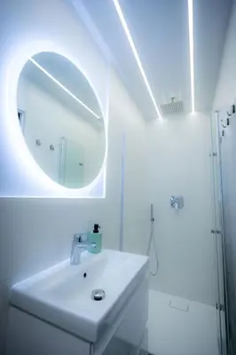 a white bathroom with a sink and a mirror at Czas i Las Glamping in Sadek