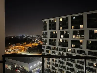 a view of a tall building at night at Parkcity Kraków in Kraków