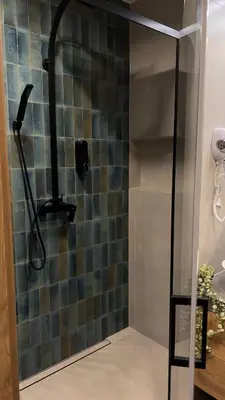 a shower with a glass door with a shower head at Parkcity Kraków in Kraków