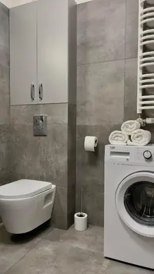 a bathroom with a washing machine and a toilet at Parkcity Kraków in Kraków
