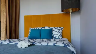 a bed with blue and white sheets and blue pillows at Parkcity Kraków in Kraków