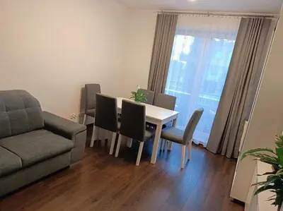 a living room with a table and chairs and a couch at Apartament u Oli i Laury in Kraków