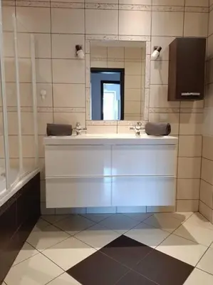 a bathroom with a sink and a mirror at Apartament u Oli i Laury in Kraków