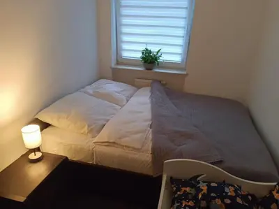 a bed in a room with a window and a lamp at Apartament u Oli i Laury in Kraków