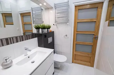 a bathroom with a sink and a toilet and a mirror at Old Town WAWEL II Premium Apartments in Kraków