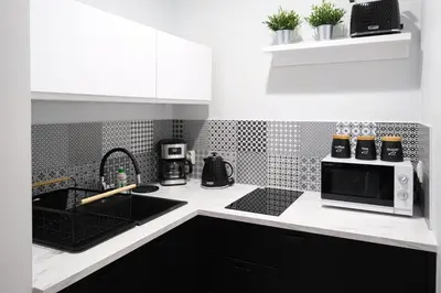 a kitchen with a sink and a microwave at Old Town WAWEL II Premium Apartments in Kraków