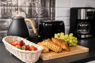 a cutting board with pastries and grapes and a basket of fruit at Old Town WAWEL II Premium Apartments in Kraków