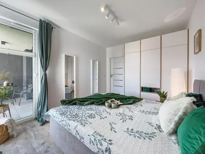 a bedroom with a large bed and a large window at Nowoczesny Apartament w okolicy Tauron Areny in Kraków