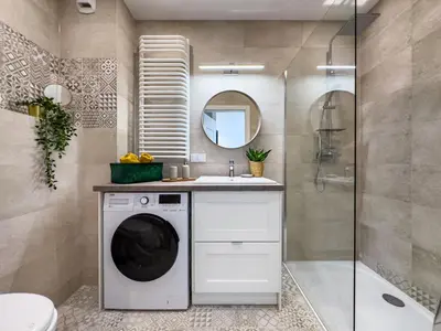 a bathroom with a washing machine and a sink at Nowoczesny Apartament w okolicy Tauron Areny in Kraków