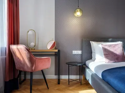 a bedroom with a bed and a desk and a chair at Tyzenhauz Suites Topolowa in Kraków
