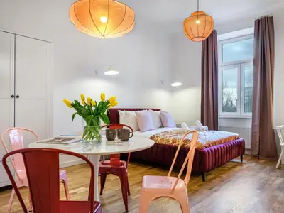 a living room with a bed and a table at Tyzenhauz Suites Topolowa in Kraków