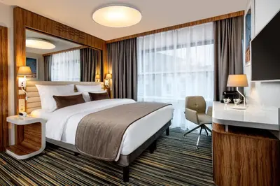 a hotel room with a large bed and a desk at Leonardo Boutique Hotel Krakow City Center in Kraków