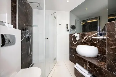 a bedroom with a large bed and a flat screen tv at Leonardo Boutique Hotel Krakow City Center in Kraków