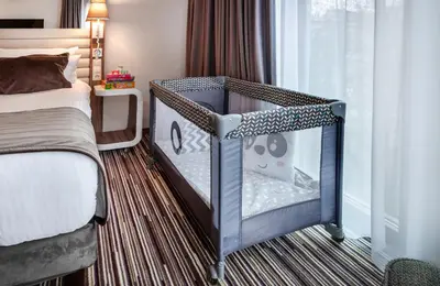 a hotel room with two beds and a chair at Leonardo Boutique Hotel Krakow City Center in Kraków