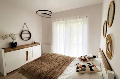 a white bedroom with a bed and a window at Malborska 29 in Kraków