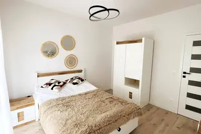 a bedroom with a bed and a chandelier at Malborska 29 in Kraków
