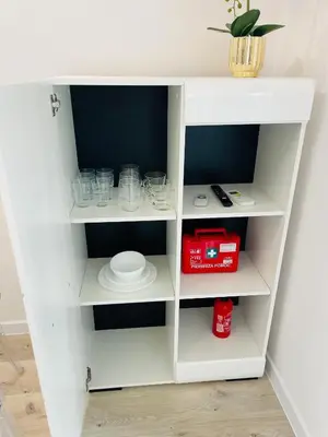 a white book shelf with cups and glasses at Apartment Barrier-Free in Kraków