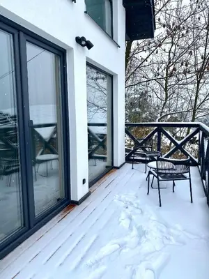 a porch with two chairs and snow on it at Domki Na Wiosce in Stryszowa