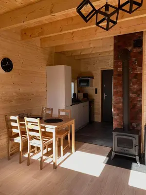 a kitchen and dining room with a table and a stove at Domki Na Wiosce in Stryszowa