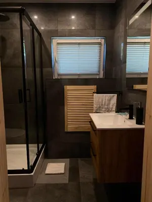 a bathroom with a shower and a sink and a glass shower at Domki Na Wiosce in Stryszowa