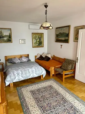 a bedroom with two beds and a table and a couch at Perfect Remote-Workplace in Sunny Apartment in Myślenice