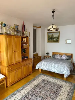 a bedroom with a bed and wooden cabinets and a rug at Perfect Remote-Workplace in Sunny Apartment in Myślenice