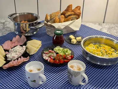 a table topped with plates of food and cups of coffee at Perfect Remote-Workplace in Sunny Apartment in Myślenice