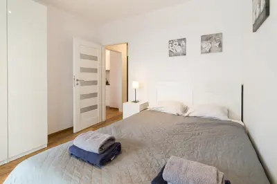 a bedroom with a bed with two towels on it at Zabłocie Comfort Suite in Kraków