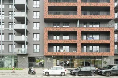 an apartment building with cars parked in front of it at Zabłocie Comfort Suite in Kraków