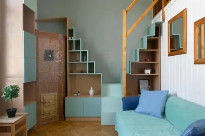 a living room with a blue couch and a book shelf at Large Apartment next to Main Station - 85 m2 in Kraków
