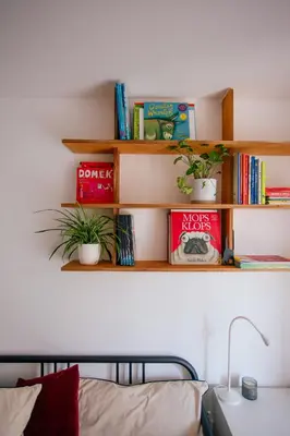 a shelf above a bed with books and plants at Nadwiślańska11 - Klimatyczny apartament tuż nad Wisłą in Kraków