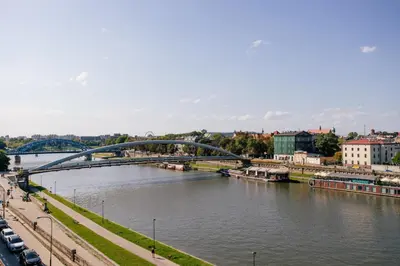 a bridge over a river with cars and buildings at Nadwiślańska11 - Klimatyczny apartament tuż nad Wisłą in Kraków