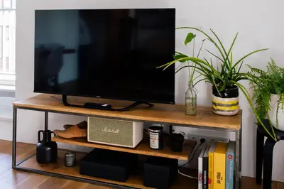 a flat screen tv sitting on top of a wooden shelf at Nadwiślańska11 - Klimatyczny apartament tuż nad Wisłą in Kraków