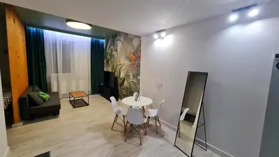 a living room with a table and white chairs at Apartment Quiet Street 11/2E in Oświęcim