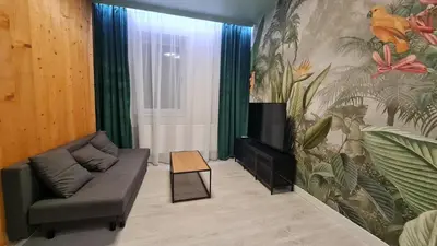 a living room with a couch and a wall mural at Apartment Quiet Street 11/2E in Oświęcim