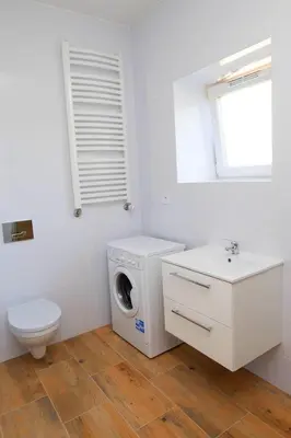 a white bathroom with a washing machine and a sink at Apartment Quiet Street 11/2E in Oświęcim