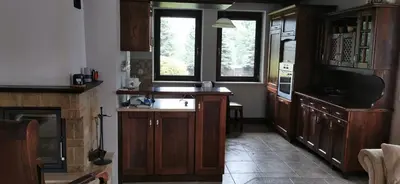 a kitchen with wooden cabinets and a sink and a window at Dom Gościnny Zawoja in Zawoja